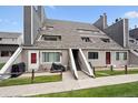 Exterior of townhomes with wood fencing, covered stairs, and well maintained lawn at 5250 S Huron Way # 1-204, Littleton, CO 80120