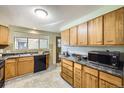 Functional kitchen with ample counter space and natural wood cabinetry at 1495 S Chase Ct, Lakewood, CO 80232