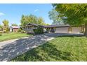 A well-maintained ranch-style home with an extended driveway and lush green lawn at 6392 S Lafayette St, Centennial, CO 80121
