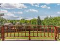 Expansive backyard view from the deck, featuring lush greenery and neighborhood homes at 7715 Estes Ct, Arvada, CO 80005