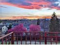 Scenic view of mountains and a colorful sunset over blooming trees from the deck at 7715 Estes Ct, Arvada, CO 80005