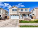 Charming two-story home featuring a two-car garage and a cozy front porch at 15333 E 98Th Pl, Commerce City, CO 80022