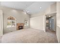 Spacious living area with high ceilings, a cozy fireplace, and a ceiling fan at 5946 S Jellison St # F, Littleton, CO 80123