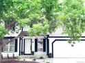 Charming white home featuring manicured landscaping and a welcoming front door framed by a mature tree at 19545 E Bates Ave, Aurora, CO 80013