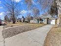 A charming house on a tree-lined street boasting curb appeal and a lovely front yard at 1221 Ulster St, Denver, CO 80220