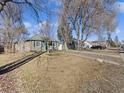 Charming home featuring mature trees, a well-kept lawn, and inviting curb appeal on a sunny day at 1221 Ulster St, Denver, CO 80220