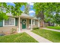 Charming front porch featuring a green door, crisp white trim, and a quaint rocking chair at 1221 Ulster St, Denver, CO 80220