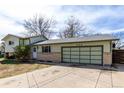 Street view of home with a large, multi-panel garage door, sunny sky above at 356 Aquarius Ct, Littleton, CO 80124
