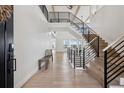Bright foyer boasts beautiful wood floors, soaring ceilings, and modern railing at 6851 Copper Sky Cir, Castle Pines, CO 80108