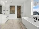Bright bathroom featuring a modern tub, a frameless glass shower, and dual sinks at 16549 Black Rose Cir, Parker, CO 80134