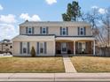 Two-story home with blue shutters, a welcoming front porch, and well-maintained lawn at 4391 S Tabor Ct, Morrison, CO 80465
