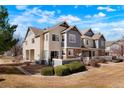 Townhouse exterior features a well-maintained lawn, beautiful facade, and a combination of stone and siding accents at 15800 E 121St Ave # 4G, Brighton, CO 80603