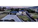 Luxury home showcasing manicured landscaping, a spacious driveway, and a three-car garage at 15902 W 64Th Ave, Arvada, CO 80007