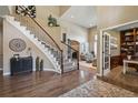 Inviting foyer featuring hardwood floors, a staircase with iron railings, and high ceilings at 14417 W 57Th Pl, Arvada, CO 80002