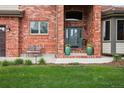 Up-close view of the home's front entrance, showcasing the door, brickwork, and landscaping at 14417 W 57Th Pl, Arvada, CO 80002