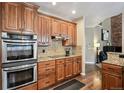 Well-appointed kitchen has modern appliances, tiled backsplash, and wood floors at 14417 W 57Th Pl, Arvada, CO 80002