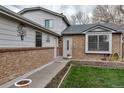 Front entrance of a charming brick-accented home with a well-manicured lawn at 45 Pierce St, Lakewood, CO 80226