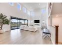 Bright living room with high ceilings, fireplace, hardwood floors, oversized windows, and neighborhood views at 6677 Crossbridge Cir, Castle Rock, CO 80108