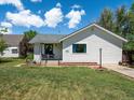 Charming single-story home with a well-maintained lawn and inviting front porch on a sunny day at 6801 W 52Nd Ave, Arvada, CO 80002