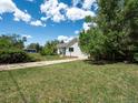 Expansive front yard with mature trees and well-manicured lawn leading to a charming single story home at 6801 W 52Nd Ave, Arvada, CO 80002