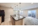 Kitchen island overlooking spacious carpeted living area and glass sliding doors at 2032 Spruce St, Denver, CO 80238