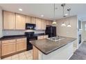 Kitchen featuring stainless steel appliances, an island, and hanging pendant lights at 2032 Spruce St, Denver, CO 80238