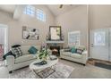 Bright living room featuring a fireplace, vaulted ceilings, and comfortable seating at 225 Longspur Dr, Brighton, CO 80601