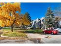 Autumn foliage surrounds a gray condo building with parking at 11109 Alcott St # D, Westminster, CO 80234