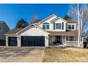 Charming two-story home with a three-car garage, well-manicured lawn, and inviting front porch at 9683 Las Colinas Dr, Lone Tree, CO 80124