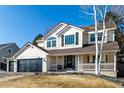 Charming two-story home with a three-car garage, well-manicured lawn, and inviting front porch at 9683 Las Colinas Dr, Lone Tree, CO 80124