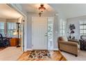 Bright entryway with hardwood floors, a white front door, and a decorative chandelier at 8233 E 149Th Dr, Thornton, CO 80602