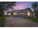 Charming single-story home with a spacious driveway and beautiful landscaping under a lovely evening sky at 8233 E 149Th Dr, Thornton, CO 80602