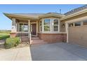 Inviting front porch with brick accents, providing a cozy entry to the home at 8233 E 149Th Dr, Thornton, CO 80602