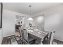 Bright dining room featuring a wood table with seating for six, a decorative rug, and modern lighting at 350 Mesa Ave, Lochbuie, CO 80603