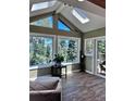 Bright sunroom features skylights, large windows with stunning views, and beautiful wood-look floors at 356 Castlewood Dr, Evergreen, CO 80439
