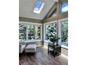 Bright sunroom features skylights, large windows with beautiful views, and wood-look floors at 356 Castlewood Dr, Evergreen, CO 80439