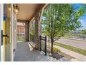 Open porch with stone supports, metal railing and ample space overlooking landscaped front yard at 10859 E 25Th Dr, Aurora, CO 80010