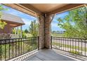 View from the porch with decorative stone pillar and black metal railing overlooking the street at 10859 E 25Th Dr, Aurora, CO 80010