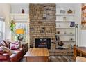 Bright living room with a stone fireplace, decorative shelves, and comfortable seating at 2182 S Victor St # D, Aurora, CO 80014