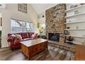Inviting living room with stone fireplace, exposed shelving, and a view of the outdoors at 2182 S Victor St # D, Aurora, CO 80014