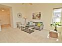Sunlit living room with neutral carpet, a modern sofa, and views from a large window at 9568 W San Juan Cir # 307, Littleton, CO 80128