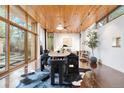 Bright dining area featuring wood ceilings, large windows, and a modern dining set with a hide rug underneath at 3665 Estes St, Wheat Ridge, CO 80033