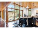 Bright dining area featuring wood ceilings, large windows, and a modern dining set with views of a courtyard at 3665 Estes St, Wheat Ridge, CO 80033