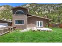 Well-maintained exterior features a bright green lawn and stunning mountain backdrop at 1500 Buckeye Cir, Georgetown, CO 80444