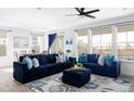 Inviting living room with cozy blue sofas, area rug, large windows and dining room in the background at 12965 Grassland St, Longmont, CO 80504