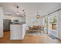 Bright dining area with hardwood floors, stylish lighting, and sliding door access to the deck at 5773 W 76Th Dr, Arvada, CO 80003