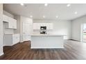 Open concept kitchen with a large island, white cabinetry and modern appliances at 2186 Flower Blossom Ave, Brighton, CO 80601