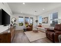 Bright living room featuring hardwood floors, large windows, and stylish modern decor at 730 Cottonwood Ave, Bennett, CO 80102