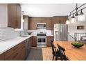 A modern kitchen with stainless steel appliances and brown cabinets for ample storage space at 16012 E Floyd Ave, Aurora, CO 80013