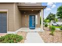 Inviting covered entryway with a blue door, complemented by professional landscaping at 18619 E 50Th Pl, Denver, CO 80249